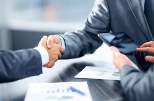 mortgage lender shaking hands at a desk over paperwork